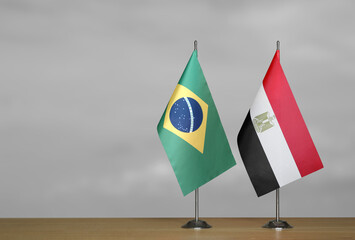 Table flags of Brazil and Egypt on gray blurred background