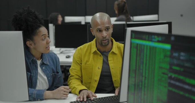 Two individuals collaborating in a modern tech office