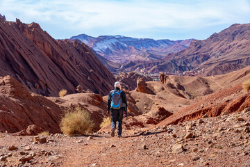 Fototapeta premium Wanderreise, Urlaub in Marokko, Dades Tal, Dades Schlucht: Wanderung im Canyon nahe der Felsen - Monkey Fingers, Pattes Des Singes: Mann, Wanderer in spektakuläre Landschaft mit roten Bergen
