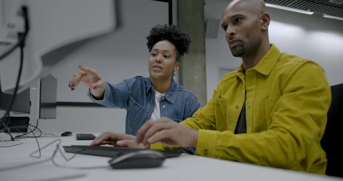 Two individuals collaborating in a modern tech office