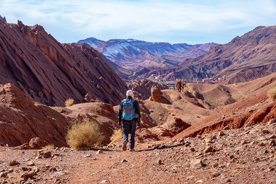 Wanderreise, Urlaub in Marokko, Dades Tal, Dades Schlucht: Wanderung im Canyon nahe der Felsen - Monkey Fingers, Pattes Des Singes: Mann, Wanderer in spektakul&auml;re  Landschaft mit roten Bergen