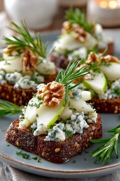 Tostada de pan integral con peras frescas, queso azul, nueces y romero, servida sobre plato r&uacute;stico.
