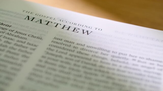 Bible Matthew book pages turn during a close up study of holy scripture. A detailed shot of flipping white paper in the first New Testament Gospel book about the life and teachings of Jesus.