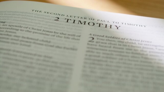 2 Timothy Bible book pages turn during a close up study of holy scripture. High-quality shot of flipping through the New Testament pastoral epistle regarding perseverance, scripture, and faith.