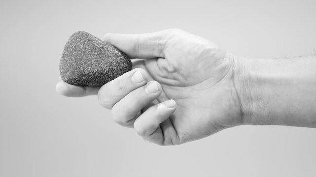 Polished Neolithic Stone Axe in Hand, Prehistoric Artifact Heritage. 4k at 50 fps. black and white. white background.  perfect condition