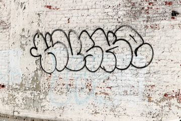 Graffiti on Weathered White Brick Wall