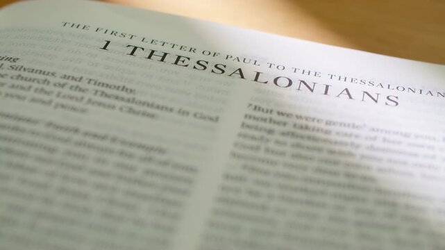 1 Thessalonians Bible book pages turn during a close up study of holy scripture. High-quality shot of flipping through the New Testament epistle regarding hope, holiness, and the second coming.