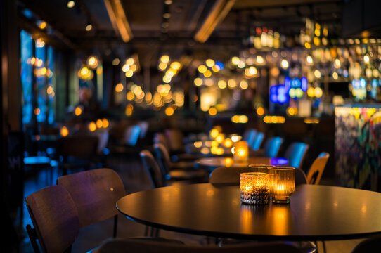 Elegant Ambient Dining Experience with Soft Candlelight and Warm Decorative Lighting in a Cozy, Modern Restaurant Interior