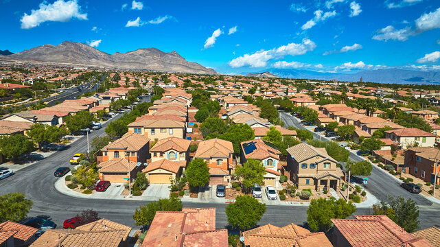 Aerial Las Vegas Residential Neighborhood With Mountain Backdrop And Blue Sky