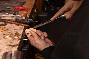 Luthier At Work: Violin Repair In A Busy Workshop With Tools And Craftsmanship © Olga