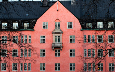 Building exterior with a lot of windows and pink wall.