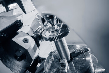 Milling machine cuts teeth on steel gear. CNC makes large wheel, industry work © Parilov