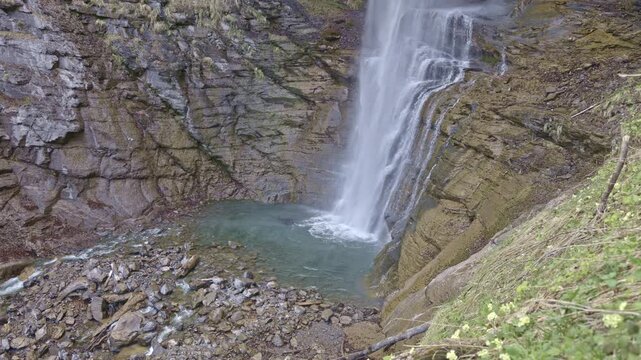 Waterfall in the mountains. Water falls from the from cascades. Middle part of Diesbachfall waterfall, canton Glarus, Switzerland.