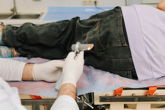 Patient examination by proctologist using anorectal diagnostic light.