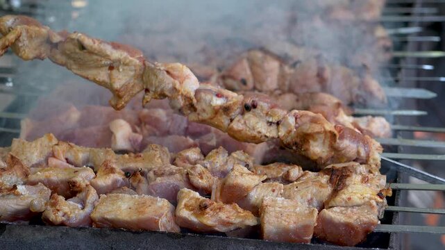 Traditional georgian mtsvadi, grill on the coals with smoke. Shashlik, barbecue. Slow motion
