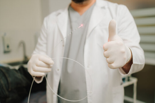 Laser therapy session for hemorrhoids performed by doctor on male patient.