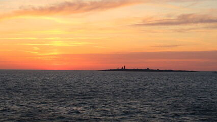 Fototapeta premium Ruhiger Sonnenuntergang über dem Meer mit weiter Horizontlinie. Sanfte Wellen, warmes Abendlicht und klare Farben erzeugen eine entspannte, zeitlose Stimmung von Freiheit, Weite und Natur.