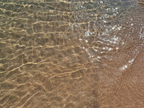 Gentle sea waves on sandy beach.