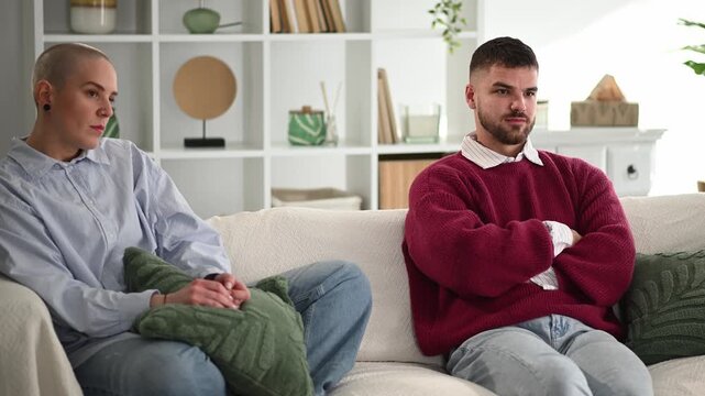 Angry couple having relationship problems on sofa