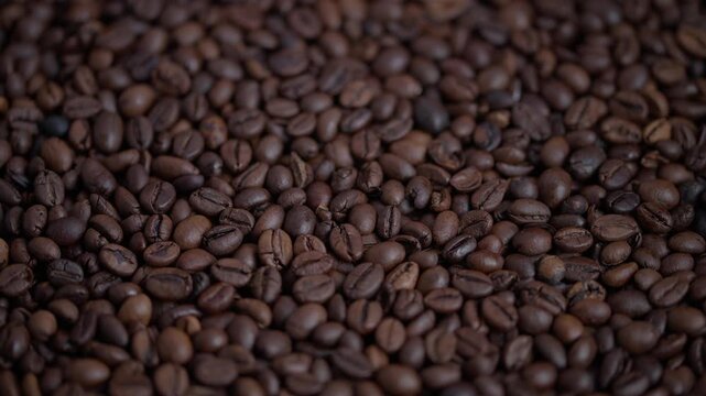 Coffee bean closeup, Close perspective capturing oily roasted coffee pod surface, Highquality macro photograph emphasizing oily sheen and textured surface of coffee beans