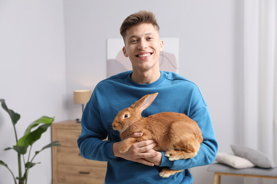 Happy man with cute bunny at home