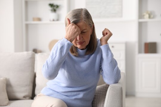 Amnesia. Senior woman trying to remember something at home