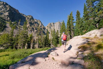 Woman Hiking on a Trail in Colorado with Forest and Mountain Peaks