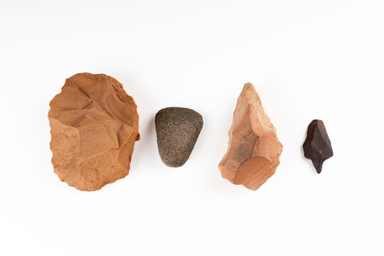 Prehistoric stone tools collection: Paleolithic biface, Neolithic polished axe, and arrowheads on white background