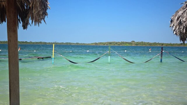 hammocks suspended over the crystal clear waters of the paradise lagoon in Jericoacoara
