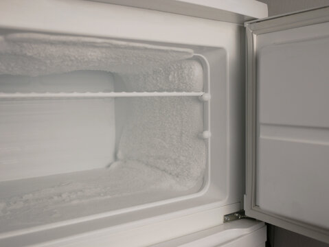 Empty freezer with heavy frost and ice buildup. Cold storage concept, refrigeration problem, defrost need, appliance maintenance, food safety, copy space