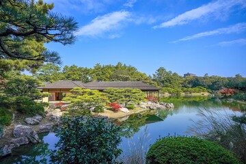 青空に映える美しい日本庭園と伝統的な数寄屋造りの建築風景