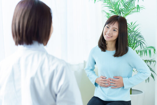 医師の診断を受ける女性　お腹　産婦人科
