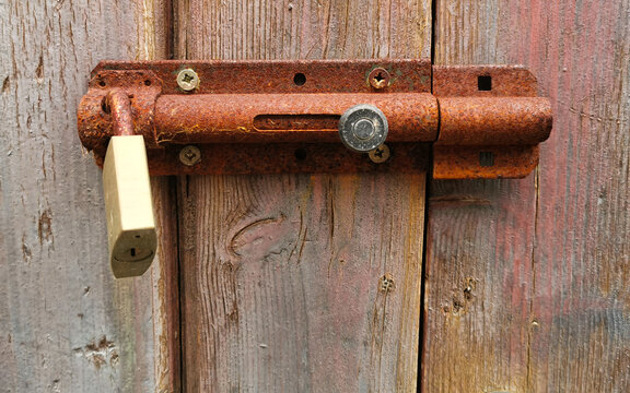 Vecchio catello arrugginito con lucchetto su vecchia porta di legno