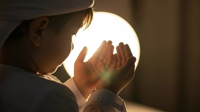 Young Middle Eastern boy in traditional white thobe and kufi praying with open hands in front of a glowing circular light, spiritual supplication and faith concept