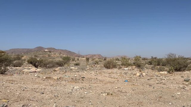 Arid Desert Landscape in Taif Saudi Arabia With Dry Soil, Sparse Shrubs, and Clear Blue Sky