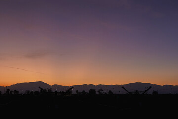 Obraz premium Colorful Sunset Sky Over Agricultural Fields With Mountains