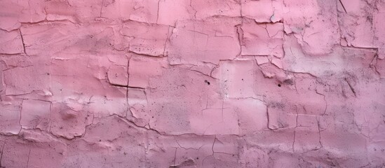 Fototapeta premium Close-up of a textured pink painted brick wall with visible cracks and imperfections.