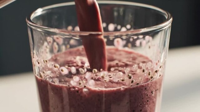 Fresh Berry Smoothie Pouring Into Clear Glass With Bubbles Texture And Healthy Drink Concept