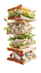 Stacked four-layer sandwich tower on white bread; lettuce and filling visible