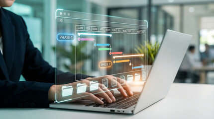 Person using a laptop to manage project phases and tasks on a digital Gantt chart, representing effective project planning and execution. © merabbi