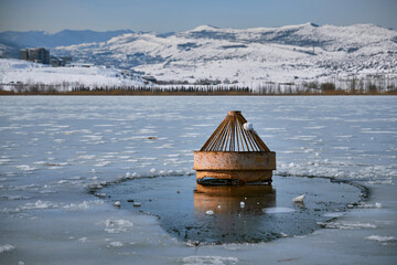 Rusty Metal Buoy in Frozen Winter Lake