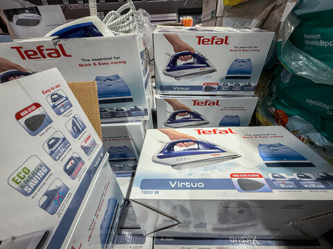 BELGRADE, SERBIA - NOVEMBER 22, 2025: Tefal Virtuo steam irons stacked on a shelf for sale in a supermarketin belgrade. Tefal is a french cookware and kitchen appliance brand part of groupe seb.