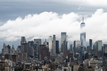 Obraz premium New York City United States skyscrapers and skyline sticking through low clouds into the heavens on an overcast day