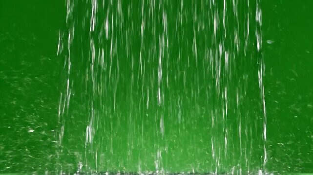 Water streams cascade down against a bright green backdrop, creating a textured visual