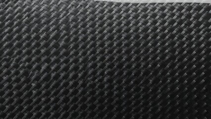 Close-up view of a dark woven material with a distinct diagonal basketweave pattern