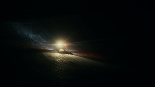 Night Snow Grooming on Ski Resort &ndash; PistenBully grooming fresh snow on empty ski run after hours.