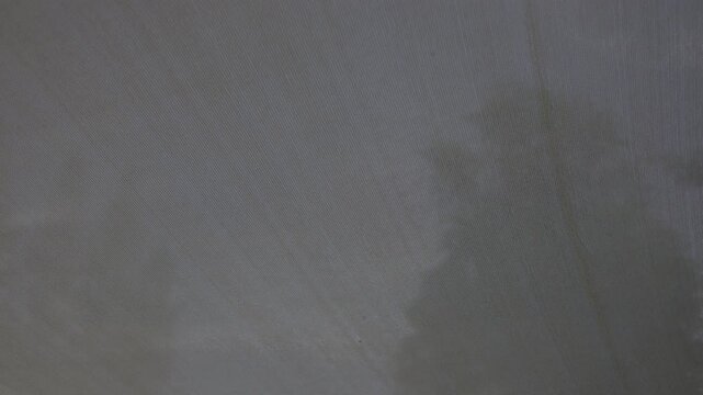 Sunshade Fabric Billowing In Afternoon Breeze, A premium film video of sunshade fabric flowing gracefully in warm, fabric edges dancing in soft glow, lifestyle comfort film or serenity documentary.