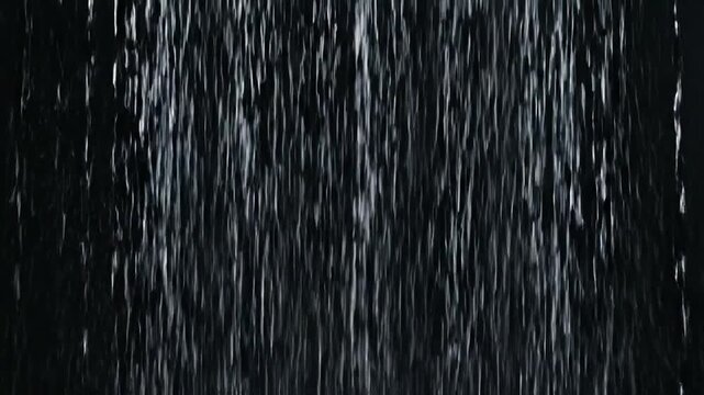 Vertical streaks of white light against a black backdrop, resembling falling water