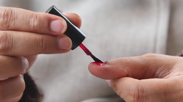 Applying nail polish in a cozy setting at home