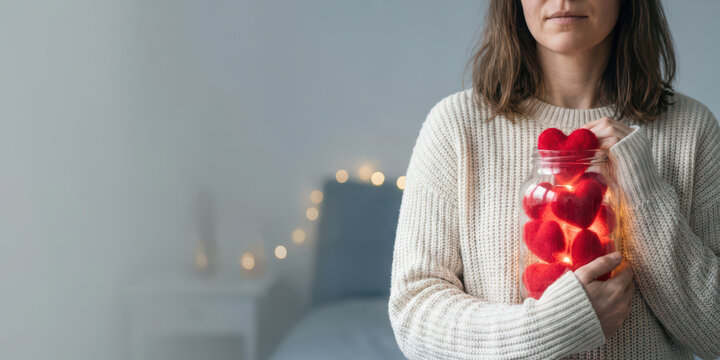 Hand jar love emotion thank with gratitude bokeh light charity care holiday concept valentine gift woman hold jar of heart shape decoration with warm nubes glow in bedroom